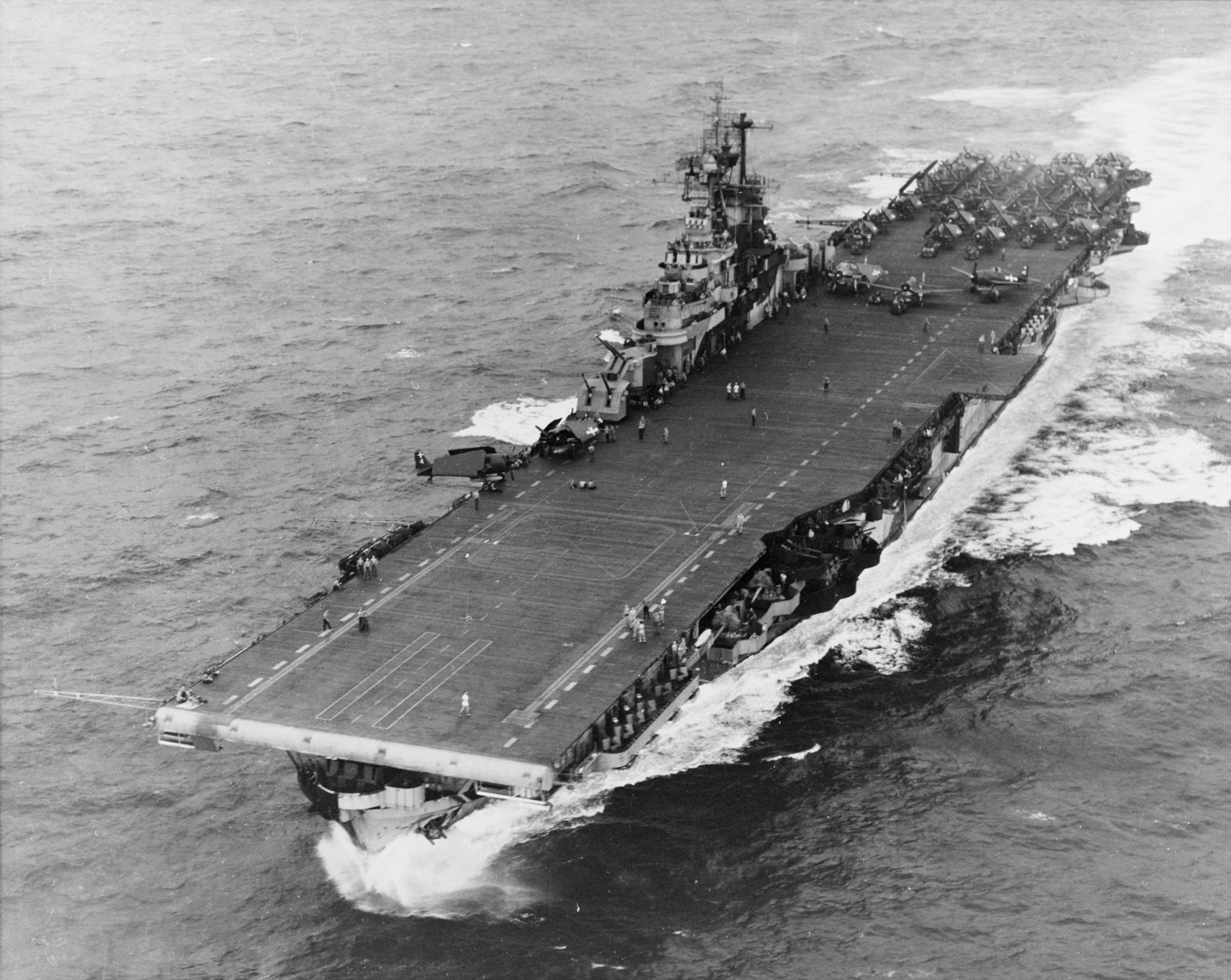 Can you identify the class (not the specific name) of the World War II-era U.S. fleet carrier in the photo?